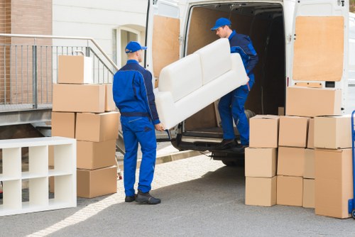 Professional movers carrying furniture during a small removal job